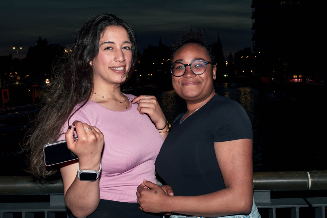 Night event portrait of two women standing by the waterfront